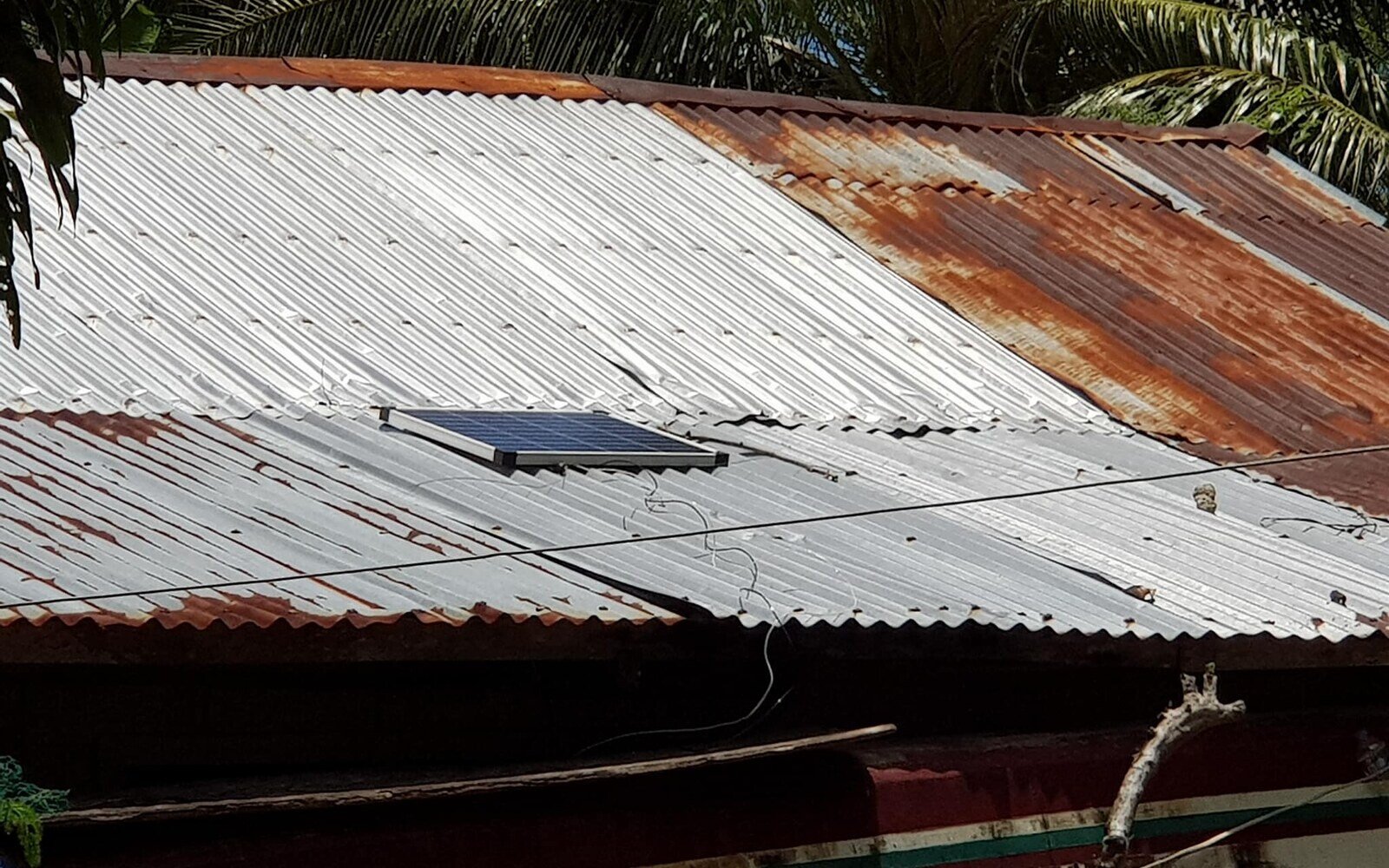 Small solar panel installed on a metal roof in Higatangan
